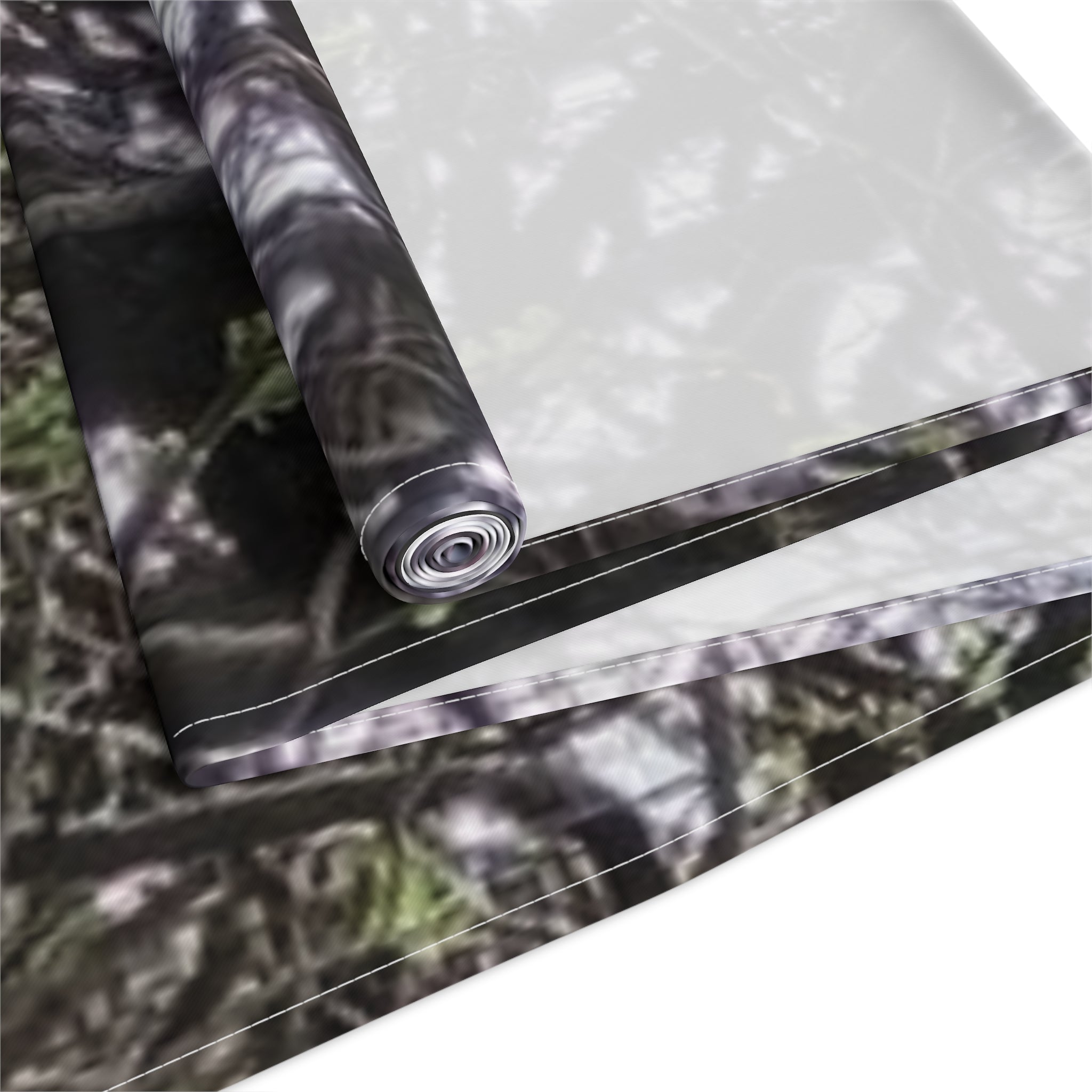 Rolled fabric with a blurred camouflage pattern.