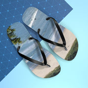 Flip-flops with a beach scene, resting on a blue patterned background.