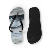 Black flip-flops with ocean-themed graphic on the left, ribbed sole on the right.