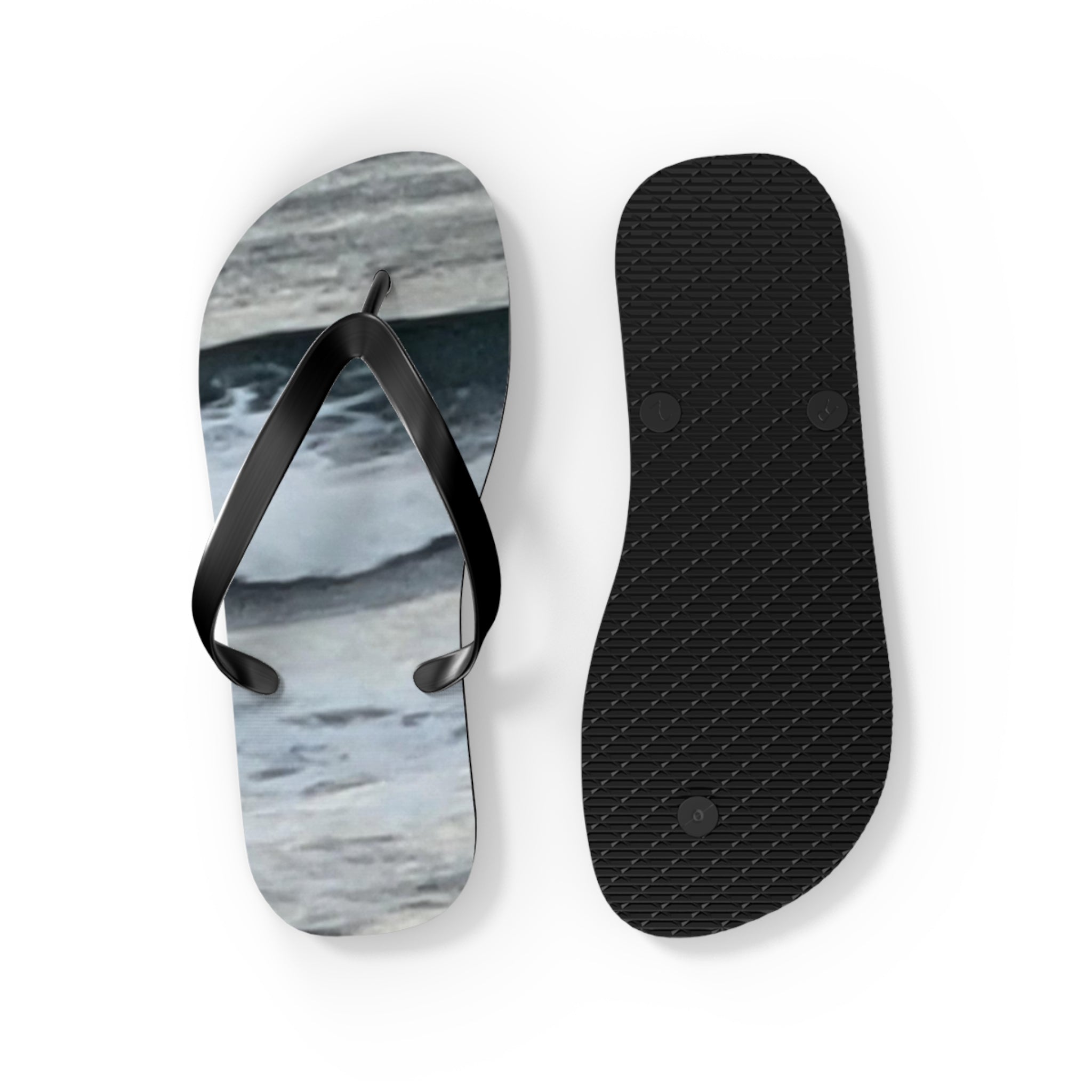 Black flip-flops with ocean-themed graphic on the left, ribbed sole on the right.