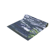 Rolled yoga mat with water and green leaf design.