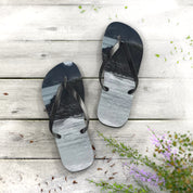 Flip-flops with a beach wave design on a wooden deck.
