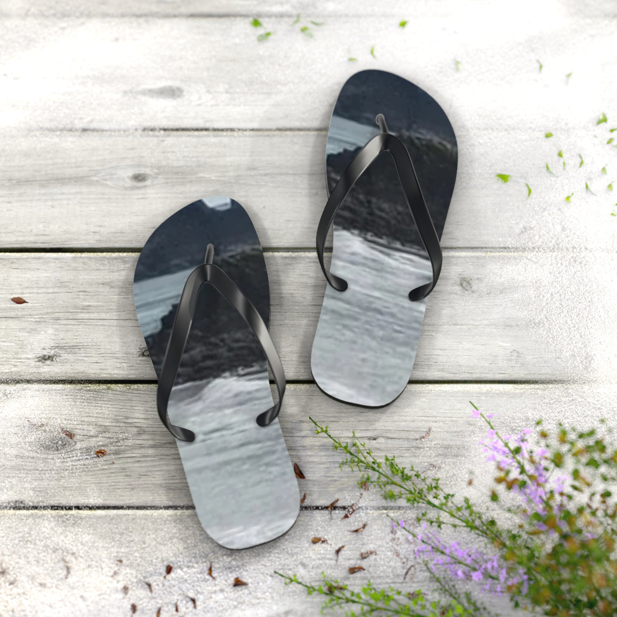 Flip-flops with a beach wave design on a wooden deck.