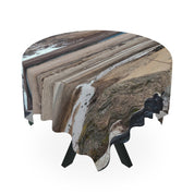 Round tablecloth with a distorted landscape print, draped over a table.