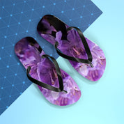Purple floral flip-flops with black straps on a blue and light blue background.