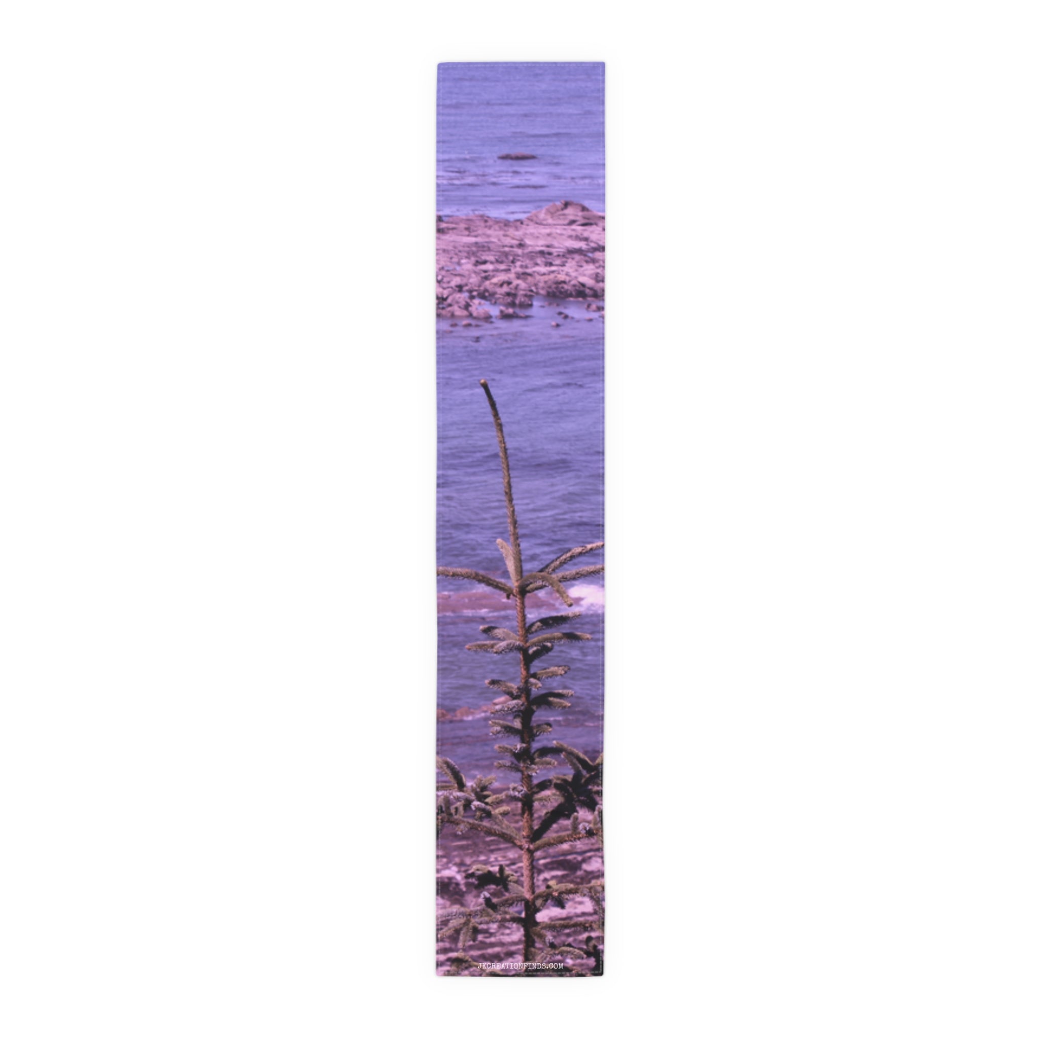 Tall, thin pine sapling in front of a rocky, purple ocean.