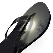 Black flip-flop with a moonlit forest scene on the sole.