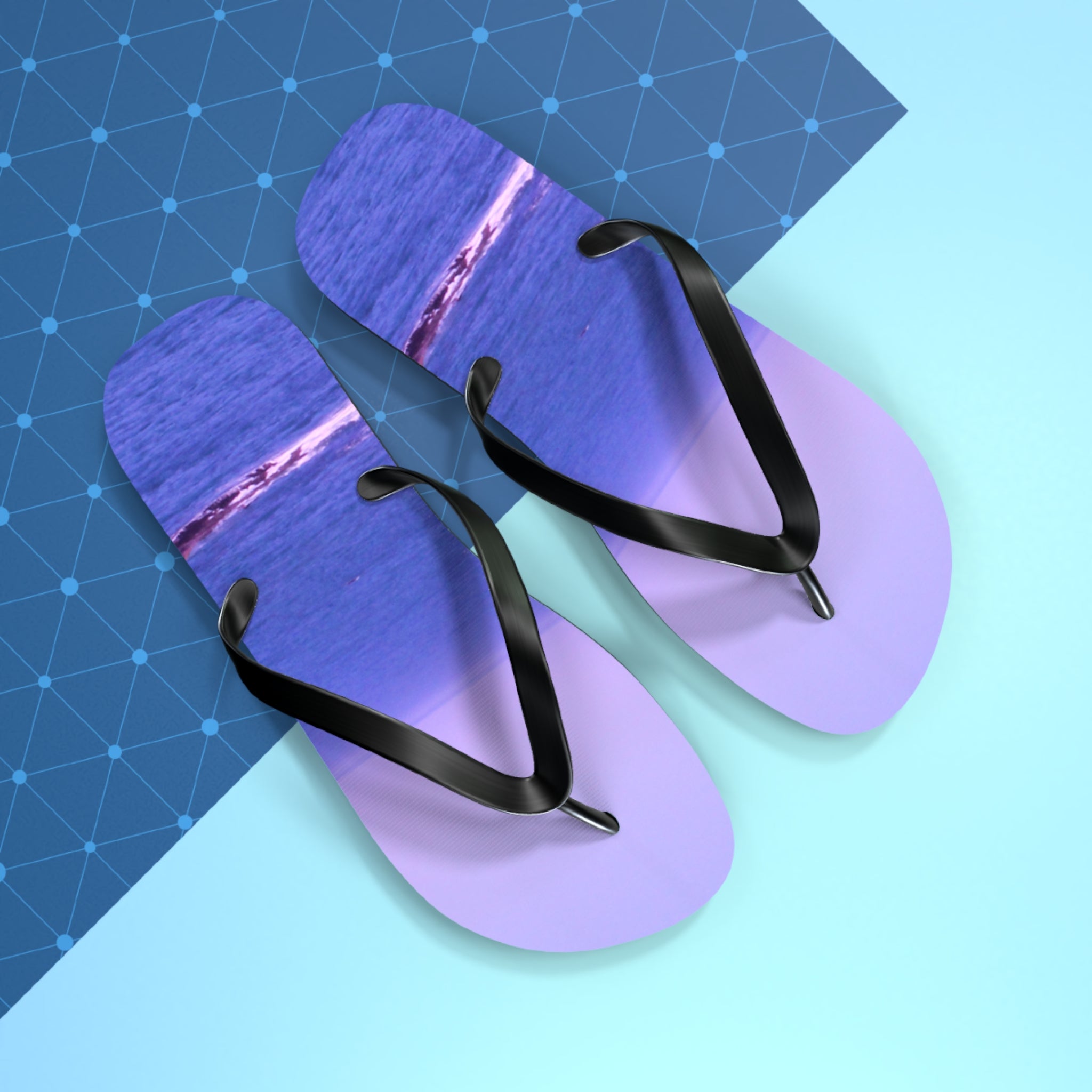 Lavender flip-flops with black straps displaying a sunset over the ocean.