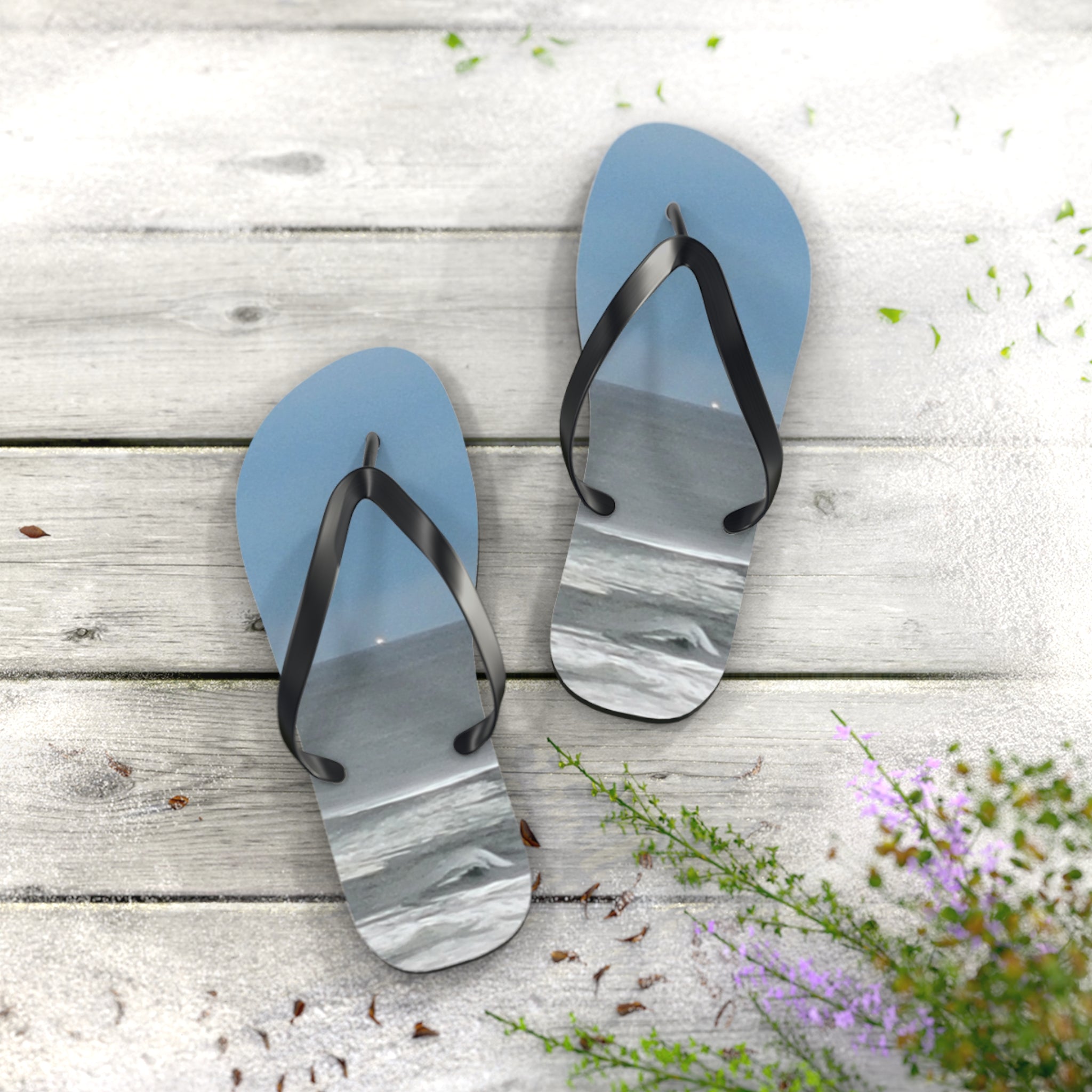 Blue flip-flops with ocean waves displayed on the straps, resting on a wooden surface.
