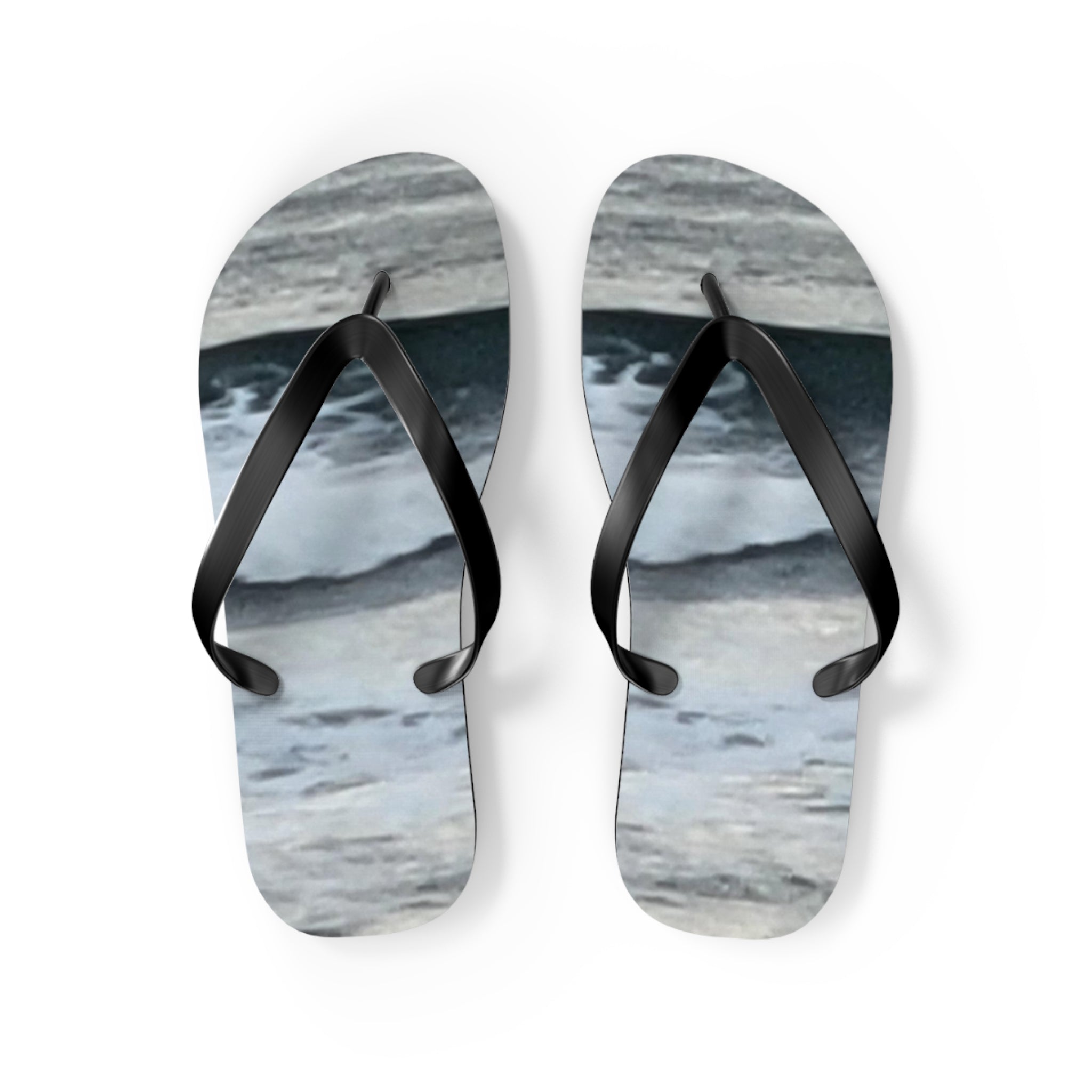 Flip-flops with a wavy water pattern and black straps.