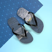 Black flip-flops with a textured gray footbed on a blue and white background.