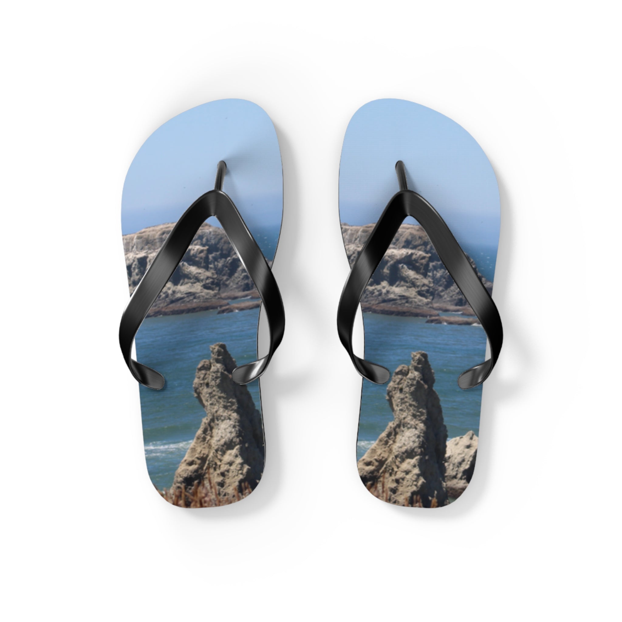 Flip flops with a rocky ocean landscape printed on the soles.