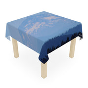 Tablecloth with a forest and mountain silhouette against a blue sky.