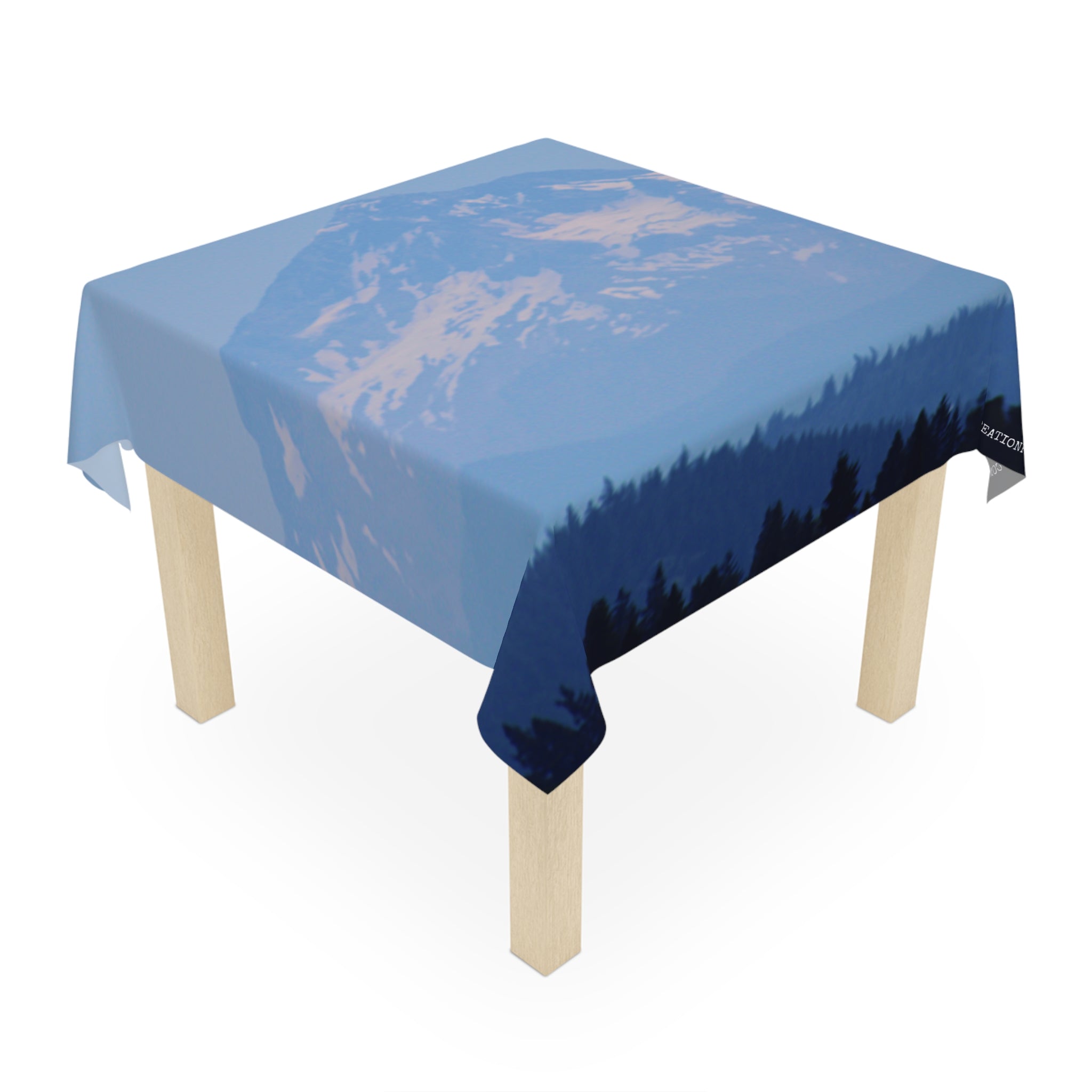Tablecloth with a forest and mountain silhouette against a blue sky.