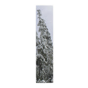Tall evergreen tree covered in snow against a muted sky.