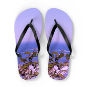 Purple flip-flops with a coastal foliage scene and a subtle watermark.