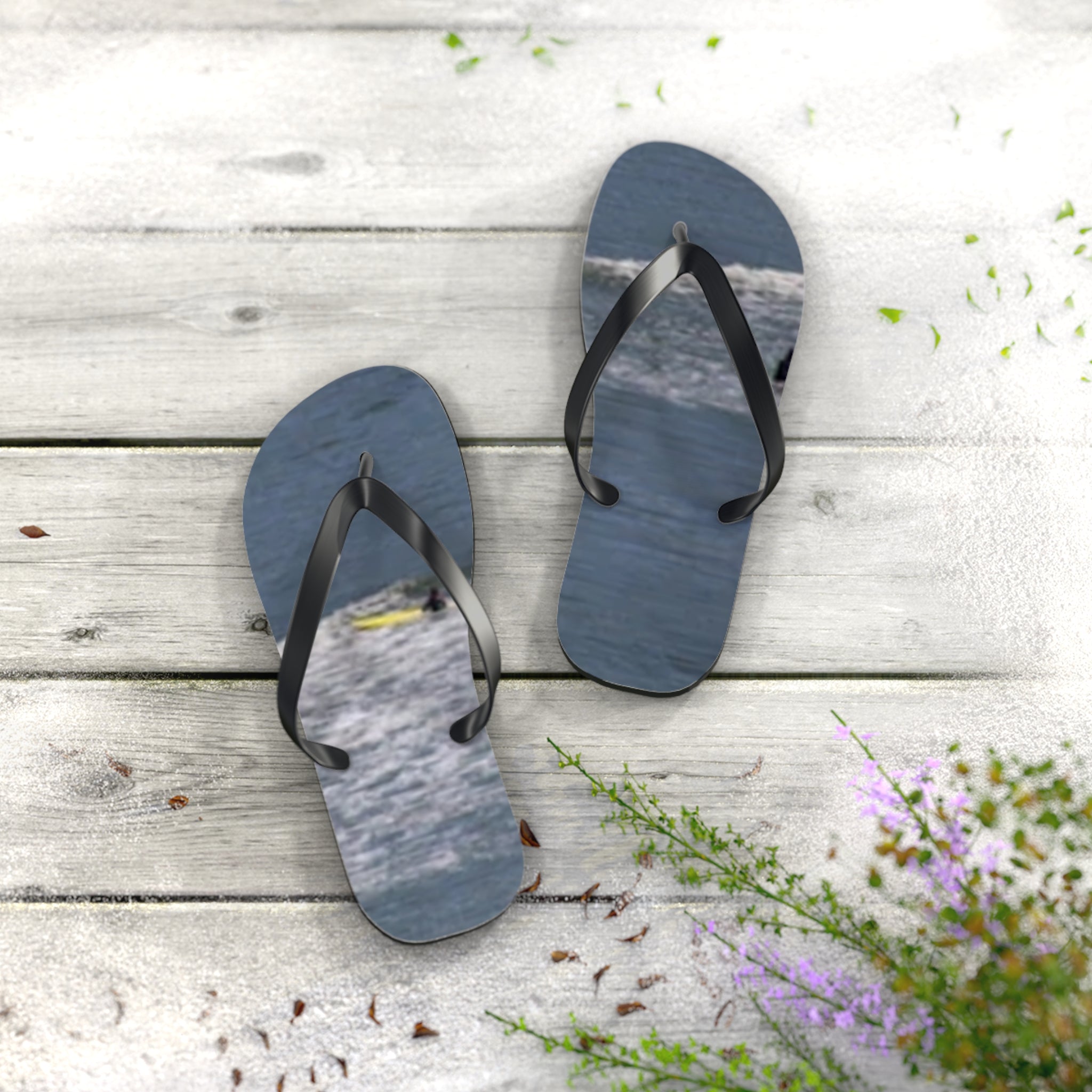 Flip-flops with ocean wave design on weathered wooden planks.