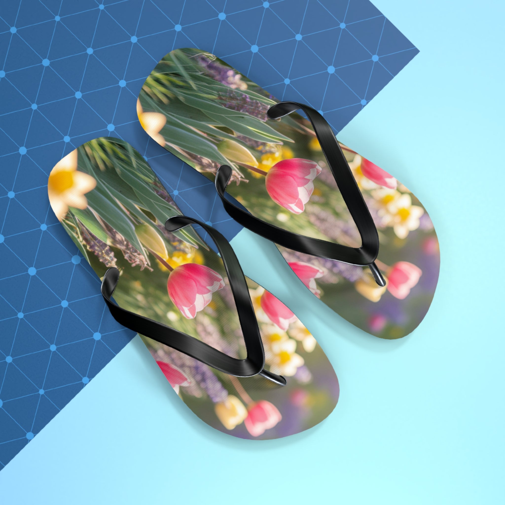 Flip-flops with a floral pattern of tulips and daffodils on a blue background.