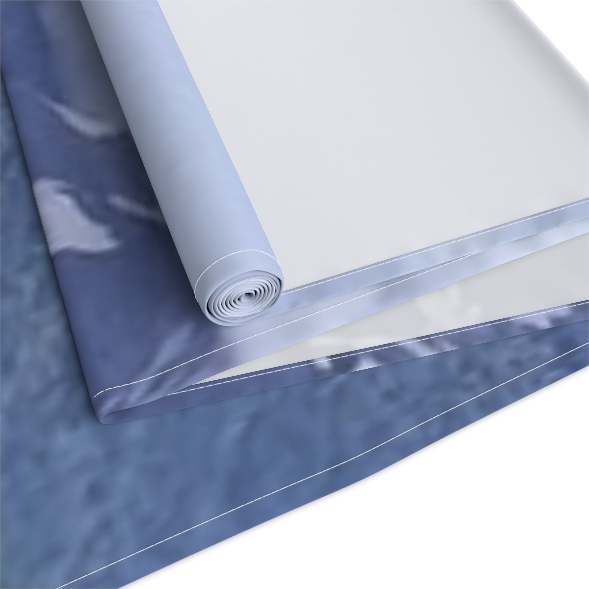 Rolled fabric with marbled blue and white pattern.