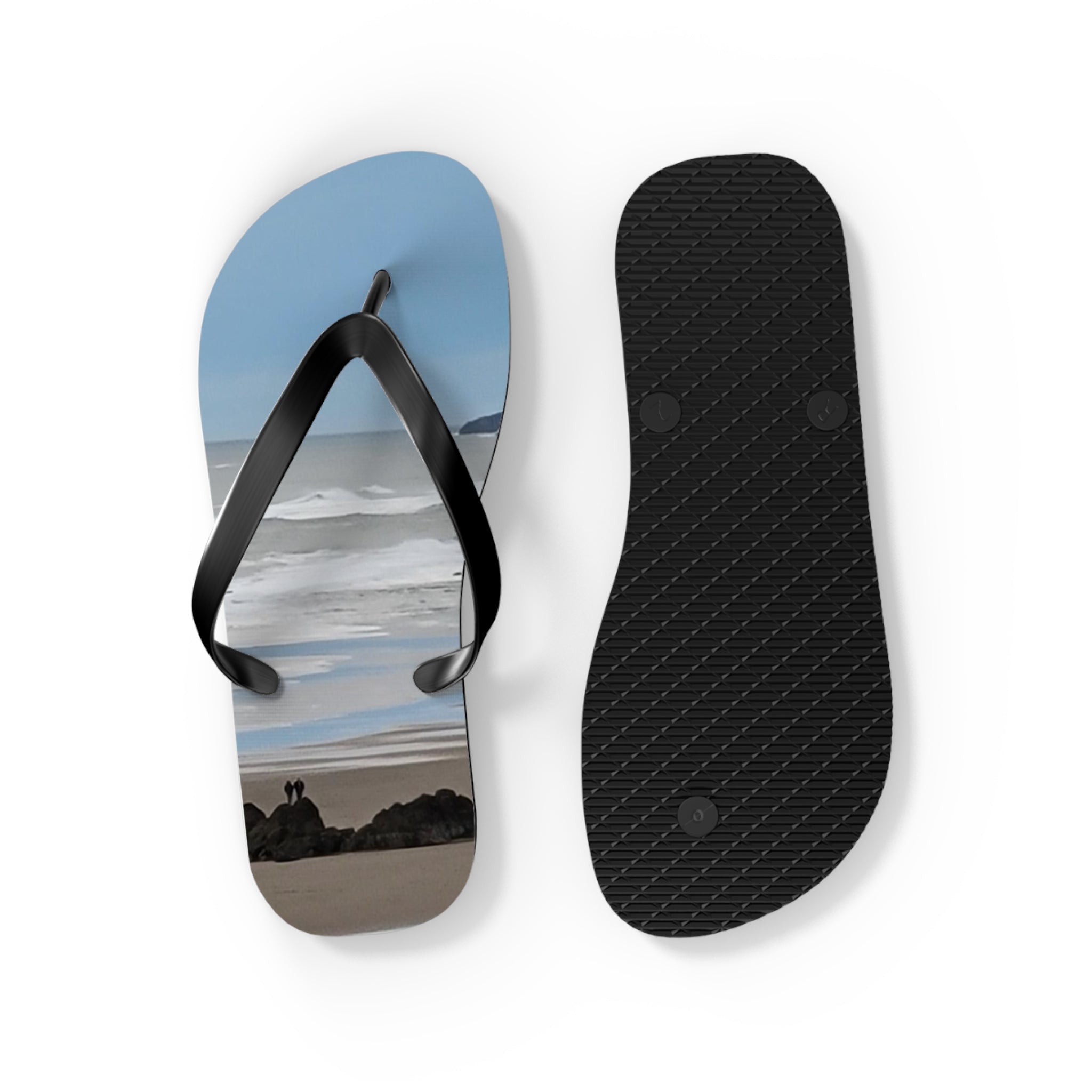 Black flip-flops with a beach scene on the right sole.