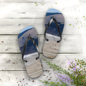 Flip-flops with a beach landscape printed on the soles, on a wooden surface.