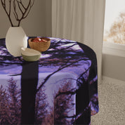 Tablecloth with a purple forest landscape pattern draped over a round table.