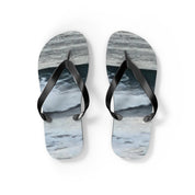 Black flip-flops with a wavy blue and gray sole pattern.
