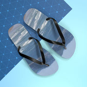 Flip-flops with a seascape scene on the soles, on a blue grid background.