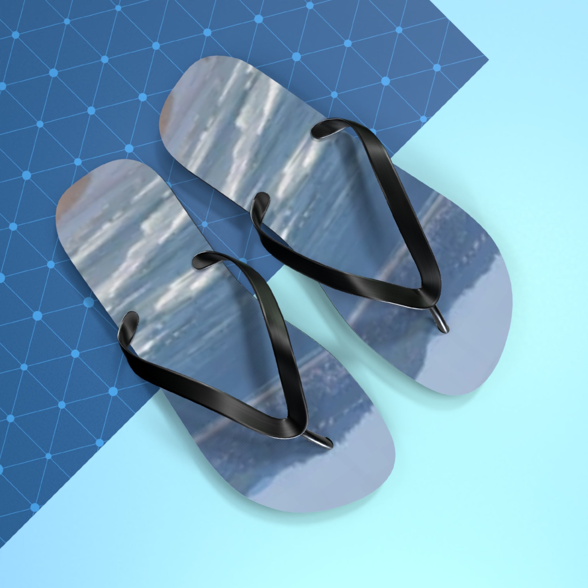 Flip-flops with a seascape scene on the soles, on a blue grid background.