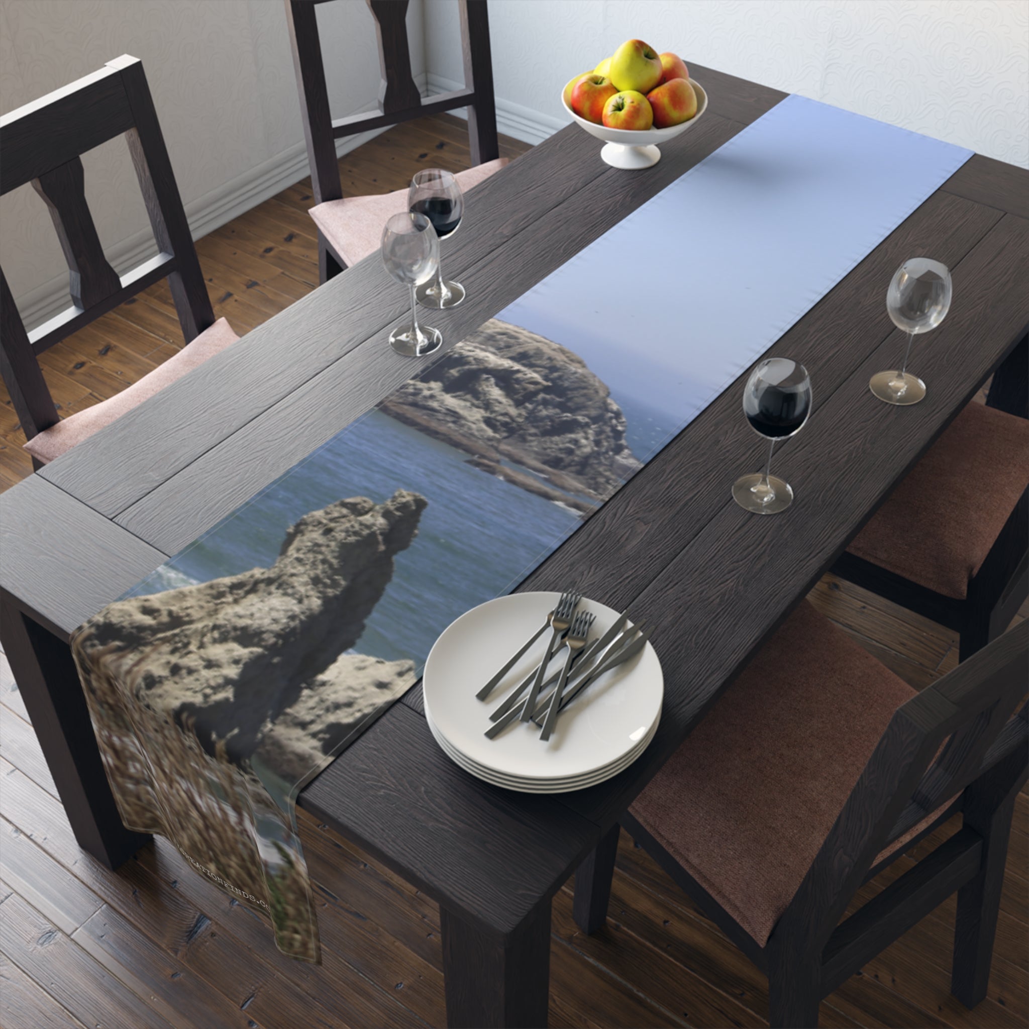 Table runner with a coastal landscape image featuring rocks and water.