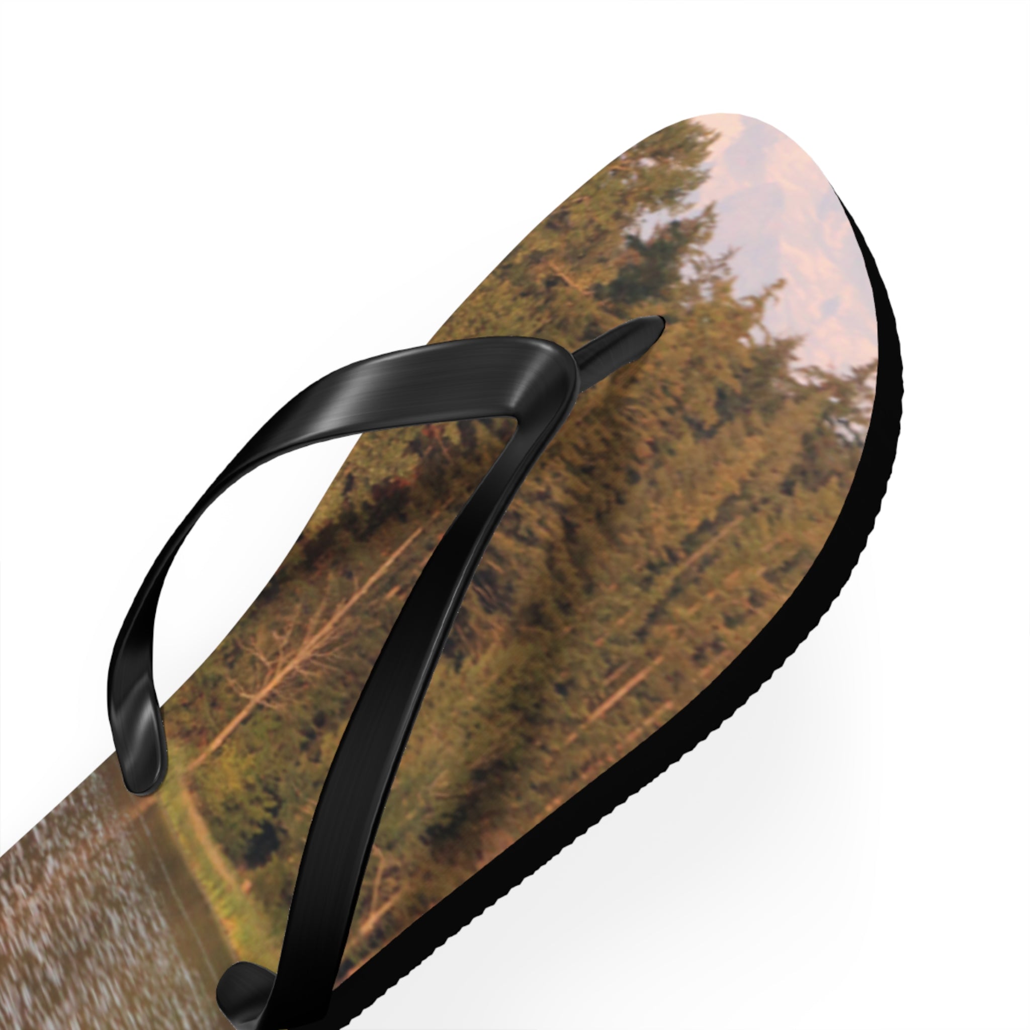 Flip-flop with a forest landscape print on the sole.