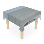 Tablecloth with a beach scene print on a wooden table.