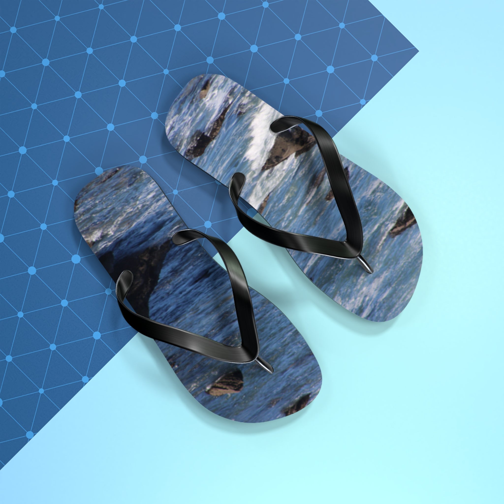 Flip-flops with a blue ocean wave and rock design on a geometric background.