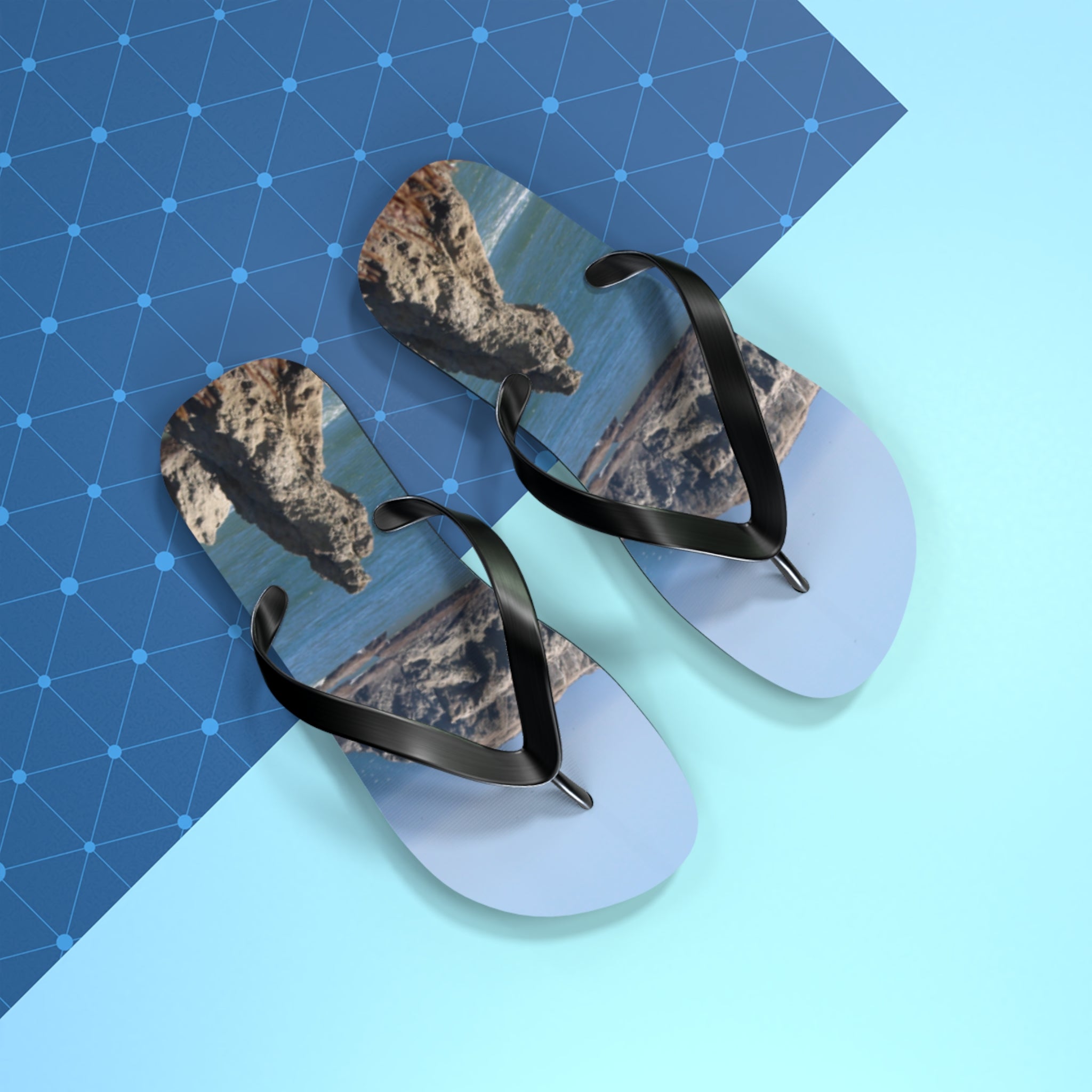 Flip-flops with a rocky coastal landscape on the soles.