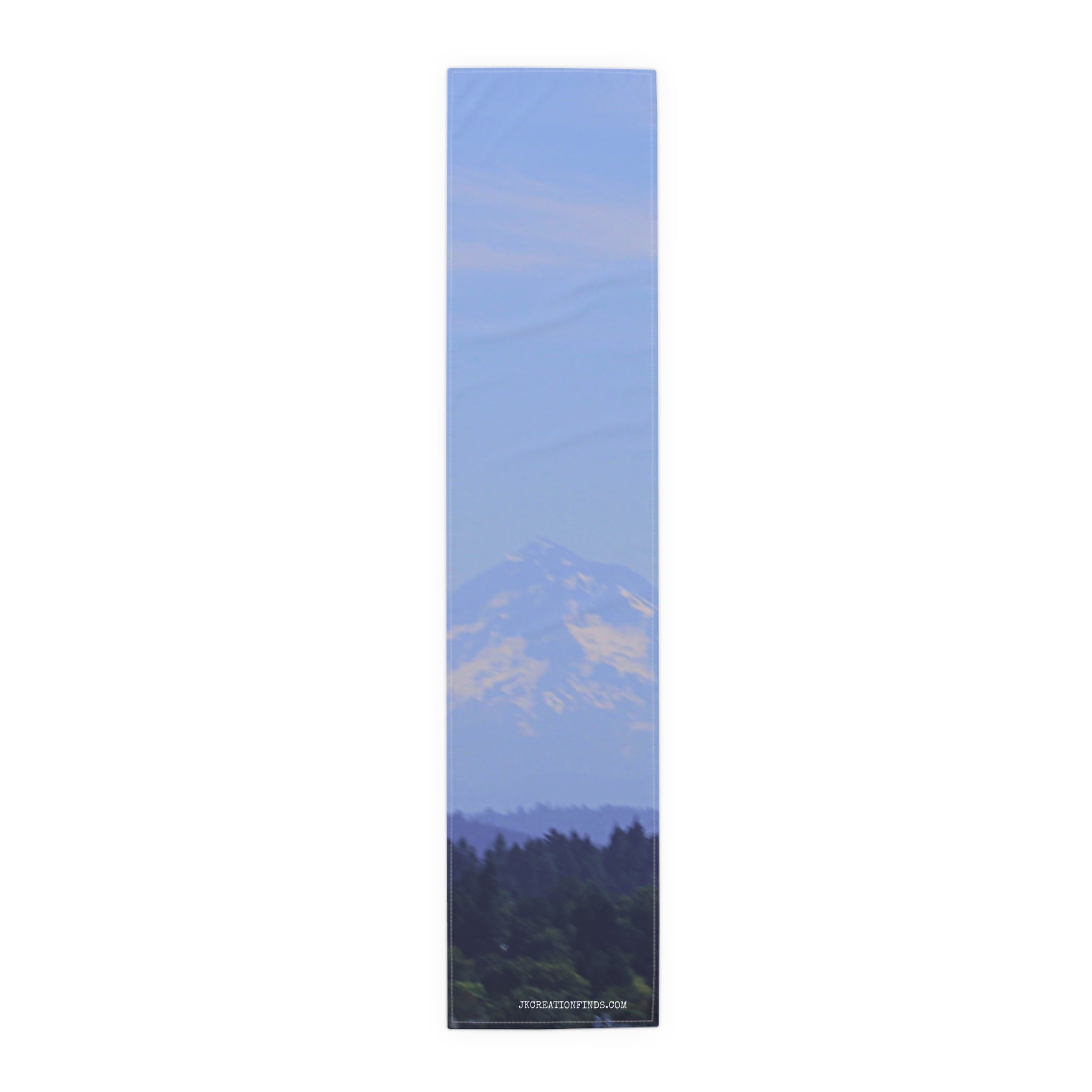 Scenic mountain range visible above dark trees under a bright blue sky.