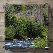 River flowing through a lush green forest with tall trees.