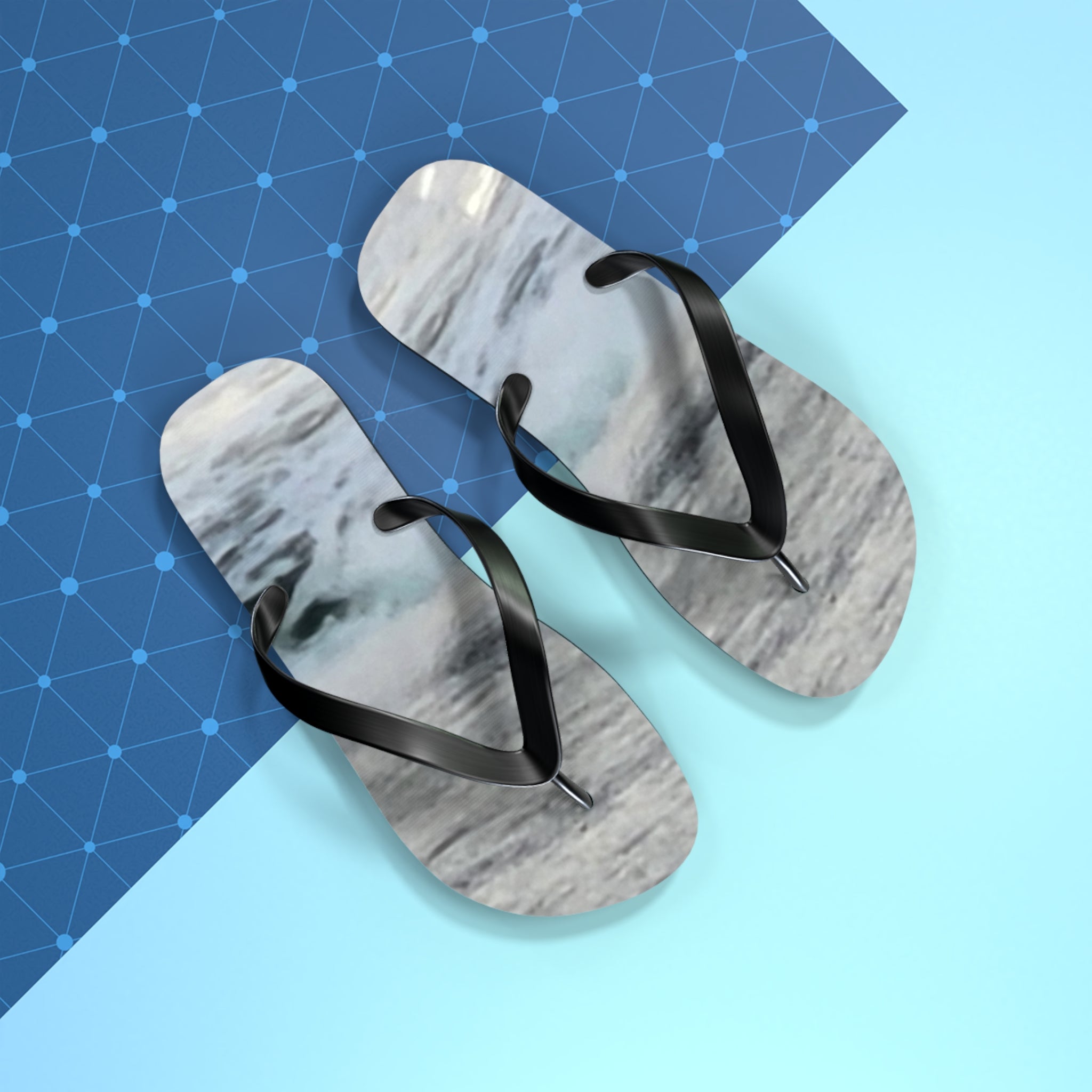 Flip-flops with a marble pattern on a blue and light blue background.