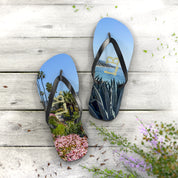 Flip-flops featuring palm trees, pink flowers, and ocean scenery.