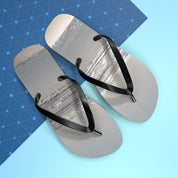 Black flip-flops with textured grey soles on a blue and white background.