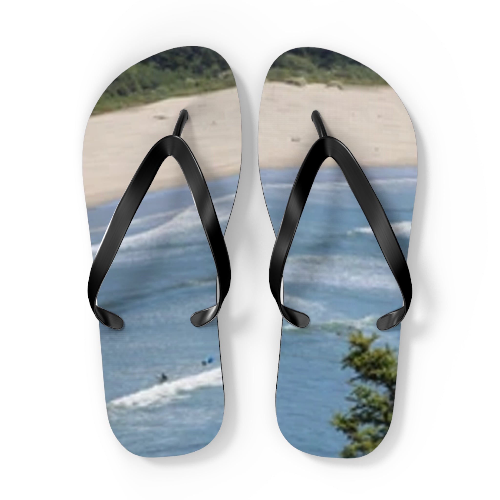 Flip-flops with a beach and ocean scene printed on the soles.