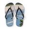 Flip-flops with a beach and ocean scene printed on the soles.