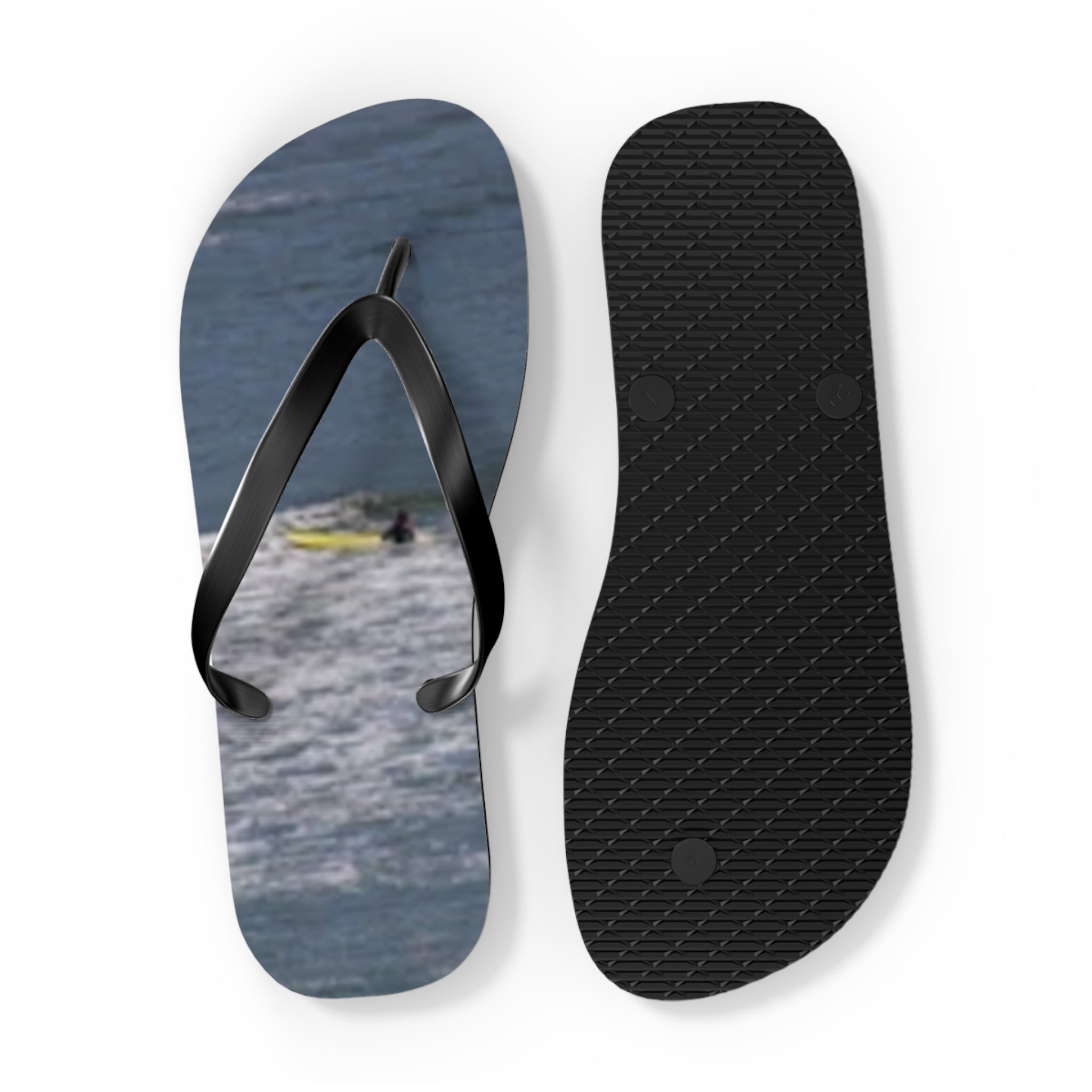 Flip-flops with a surfer on the sole and a black textured strap.
