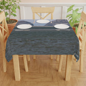 Tablecloth with ocean view and mountain backdrop.