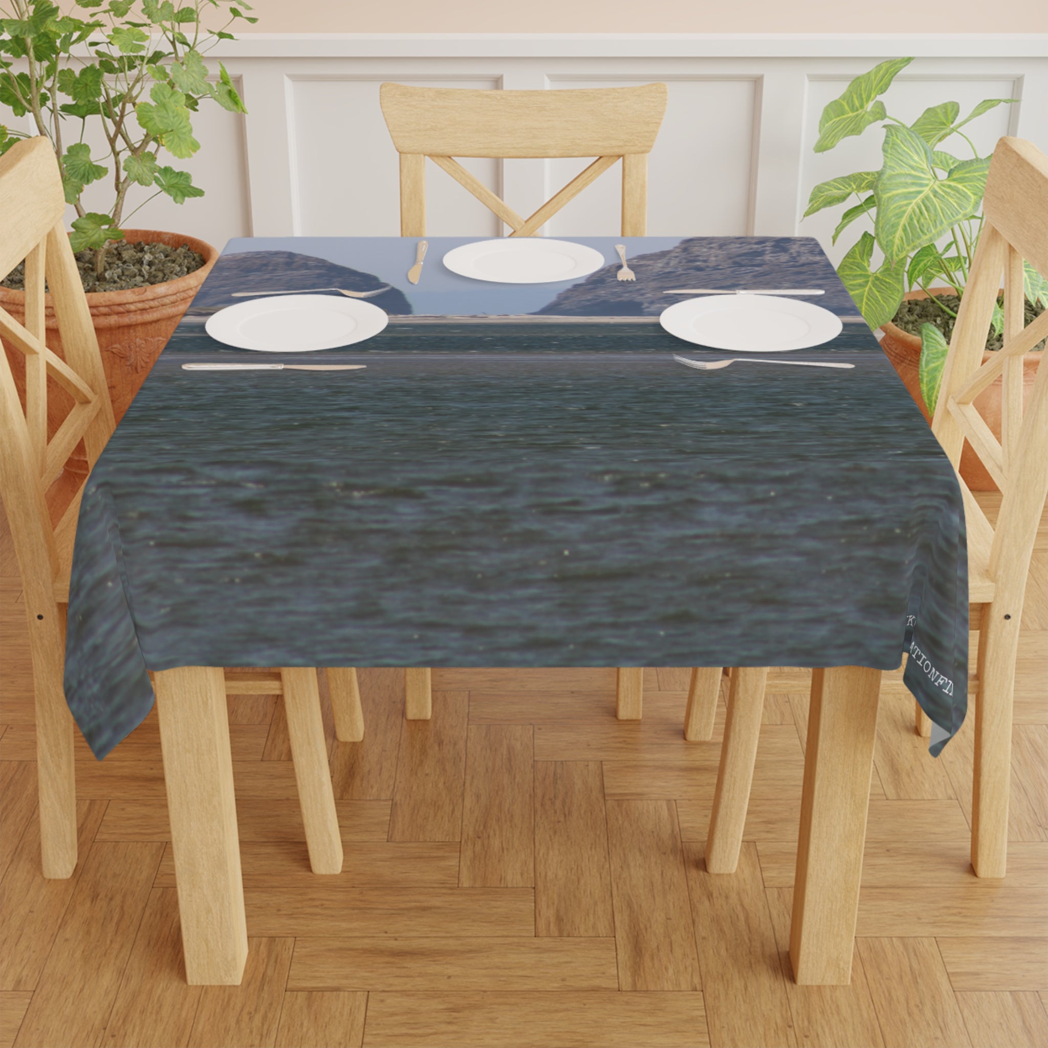Tablecloth with ocean view and mountain backdrop.