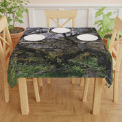 Tablecloth with mossy branches and leaves pattern on a wooden table.