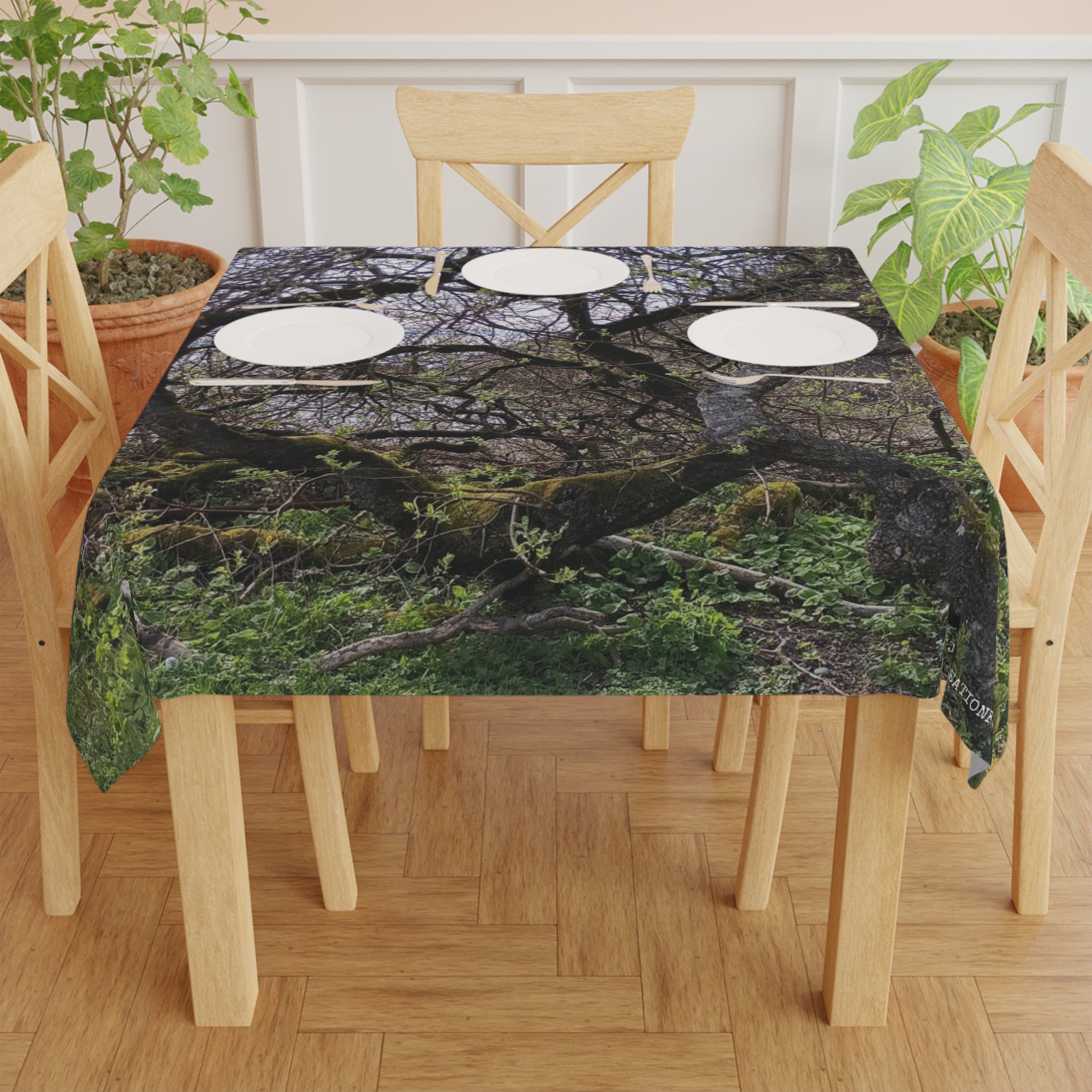 Tablecloth with mossy branches and leaves pattern on a wooden table.