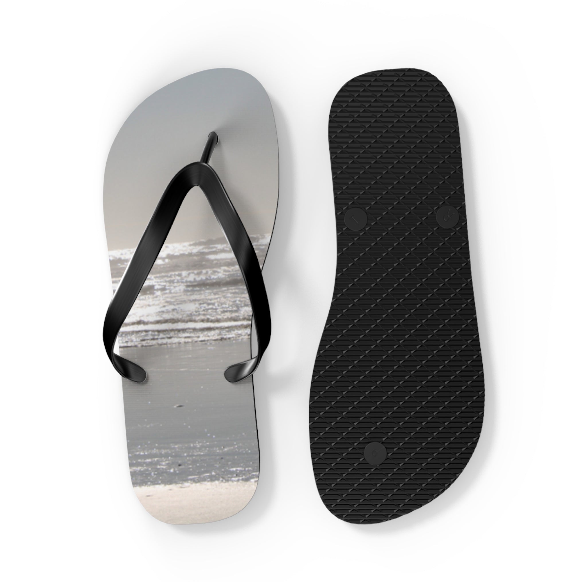 Black flip-flops with a beach scene on the footbed.