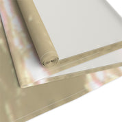 Rolled and unfolded beige fabric with a soft, abstract pattern.