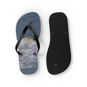 Flip-flops with a water and kayaker design on the left and black textured sole on the right.