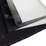 Black and white fabric unrolled, showing a dark patterned section and a white section.